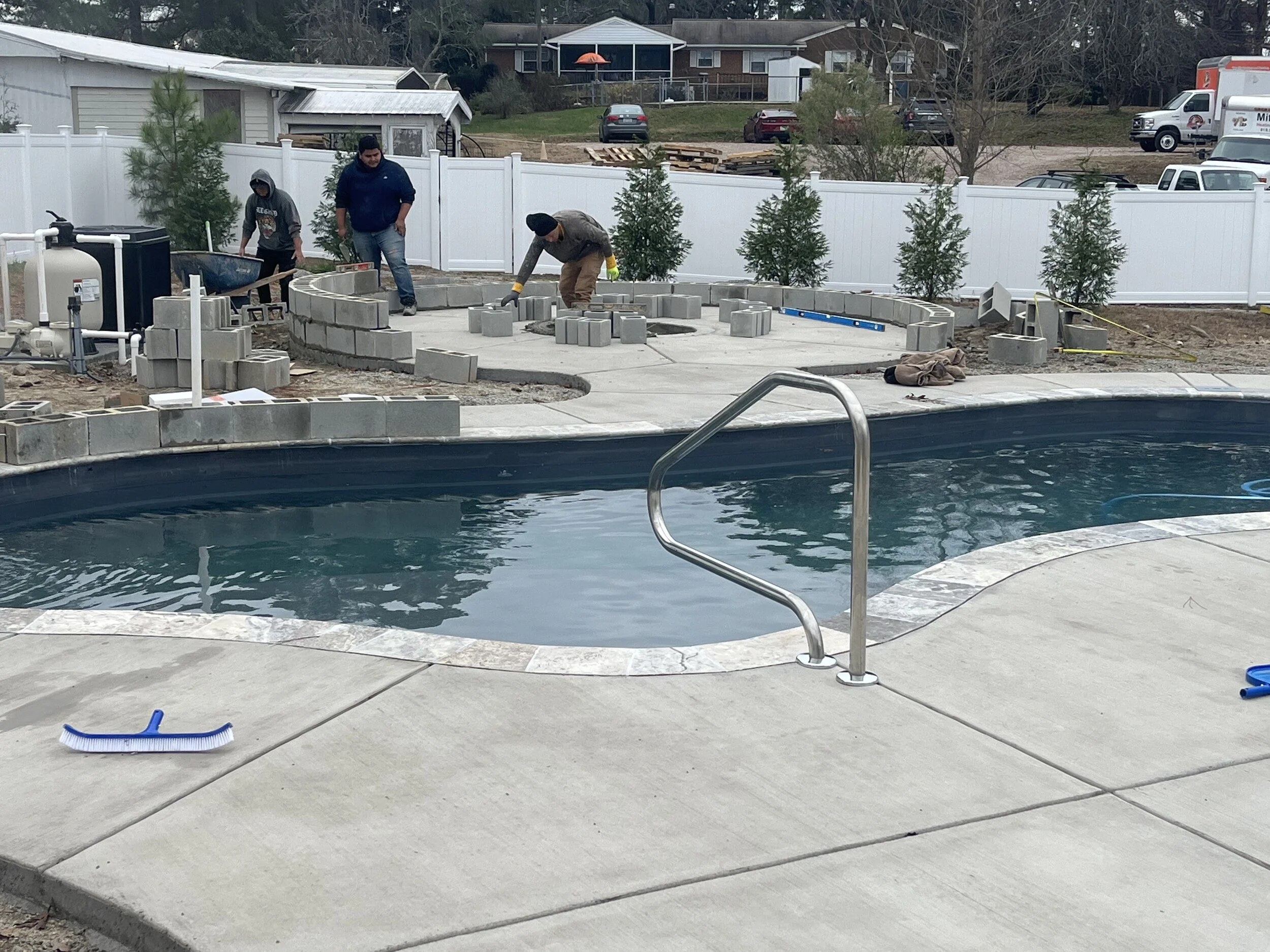 Fiberglass in-ground pool with splash pad under construction