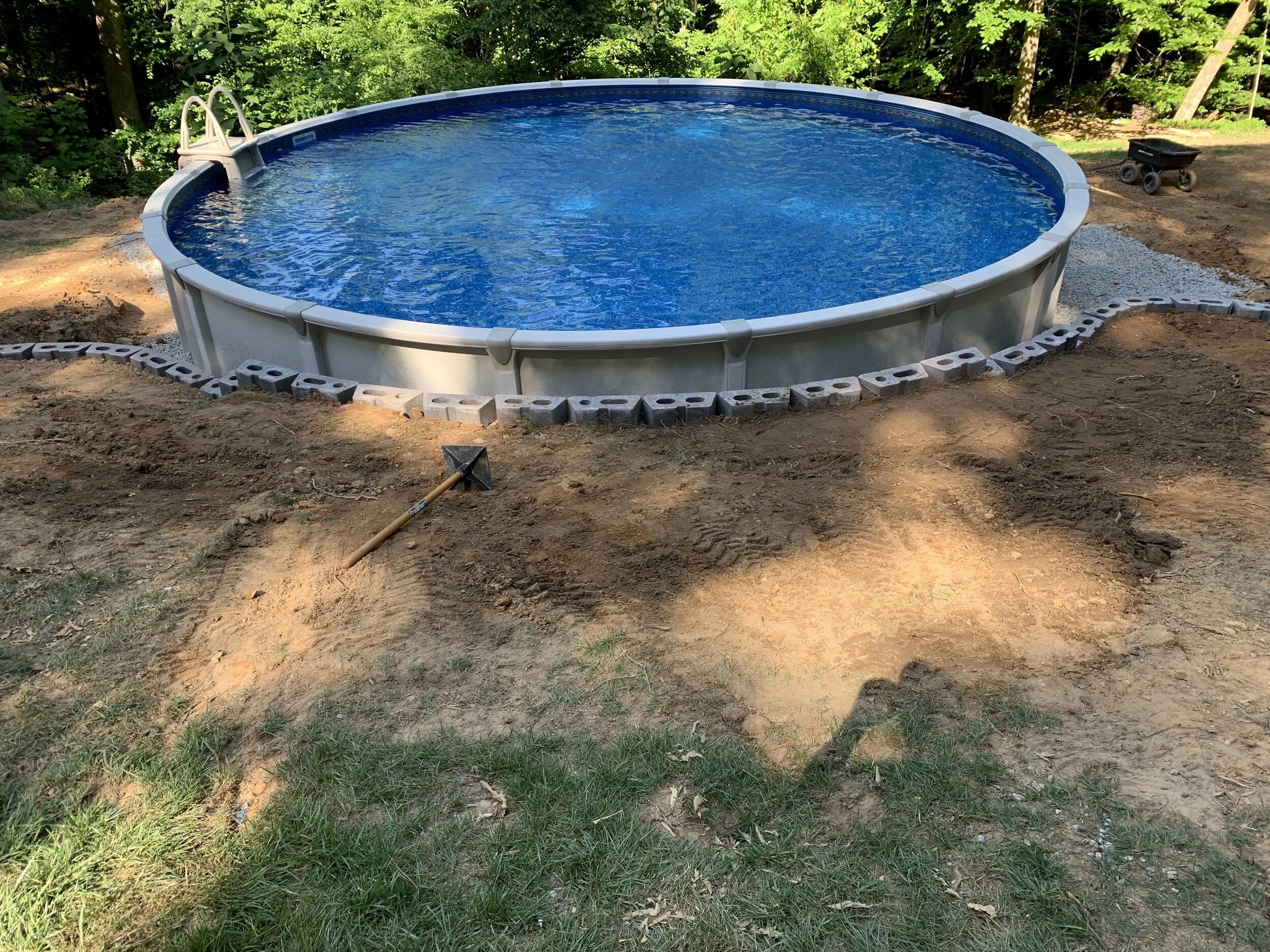 Round above-ground pool with a retaining wall